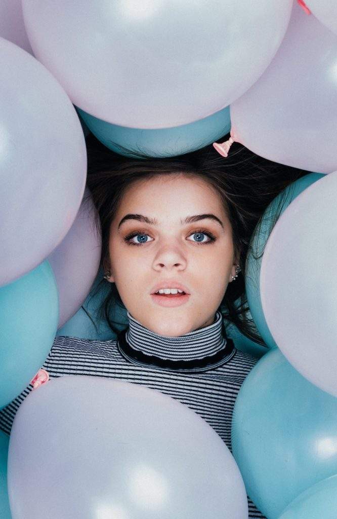 Femme entourée de ballons pastel, vue de dessus