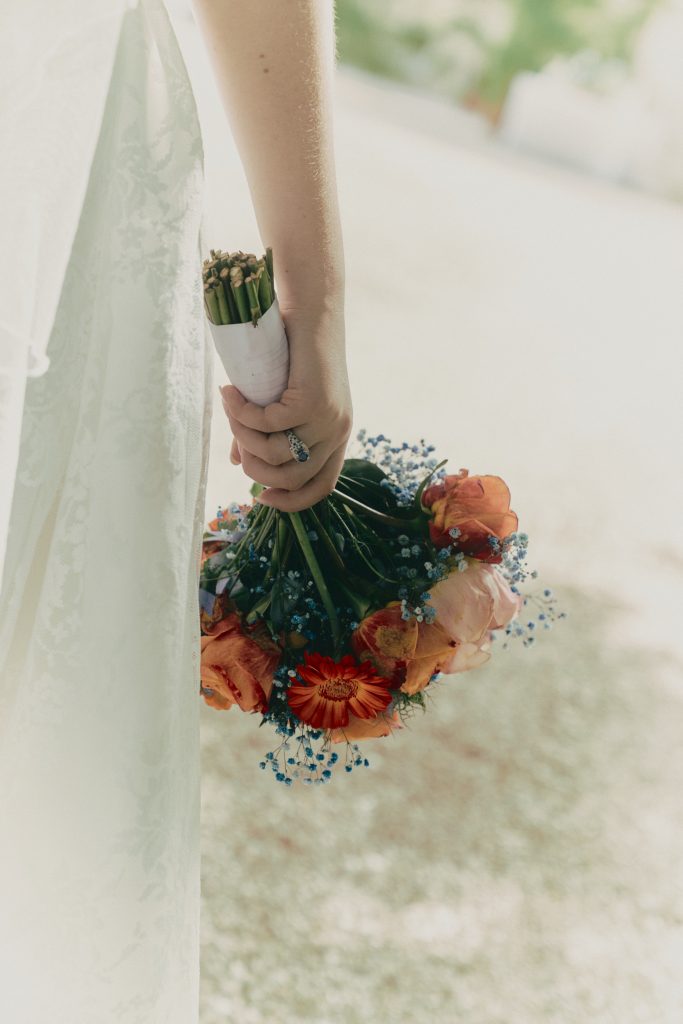 Mariée en robe blanche tenant un bouquet coloré