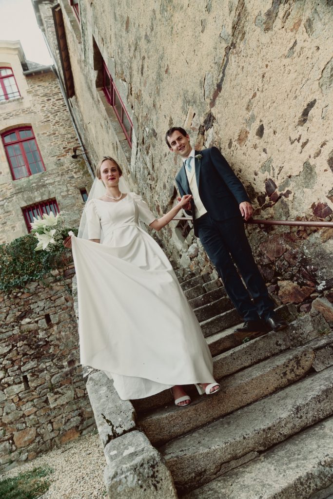 Jeunes mariés descendant des marches en pierre