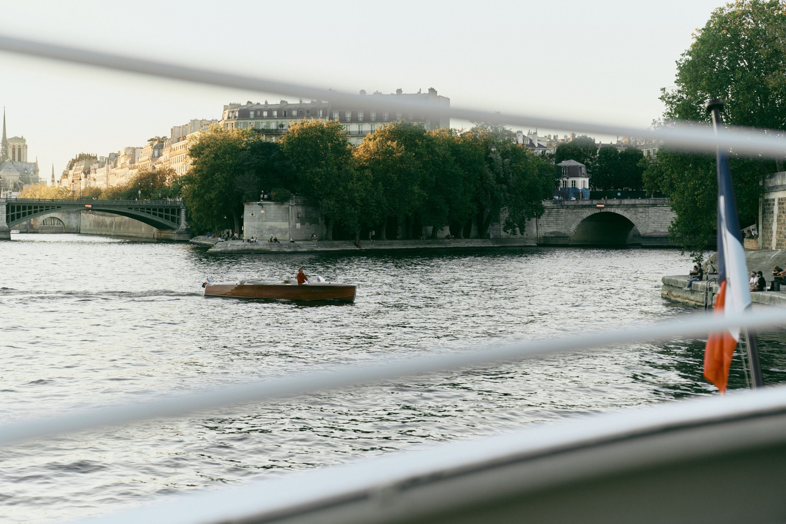 Un pont majestueux se reflète dans les eaux sombres du fleuve. Les lampadaires dorés créent une atmosphère nocturne et romantique.
